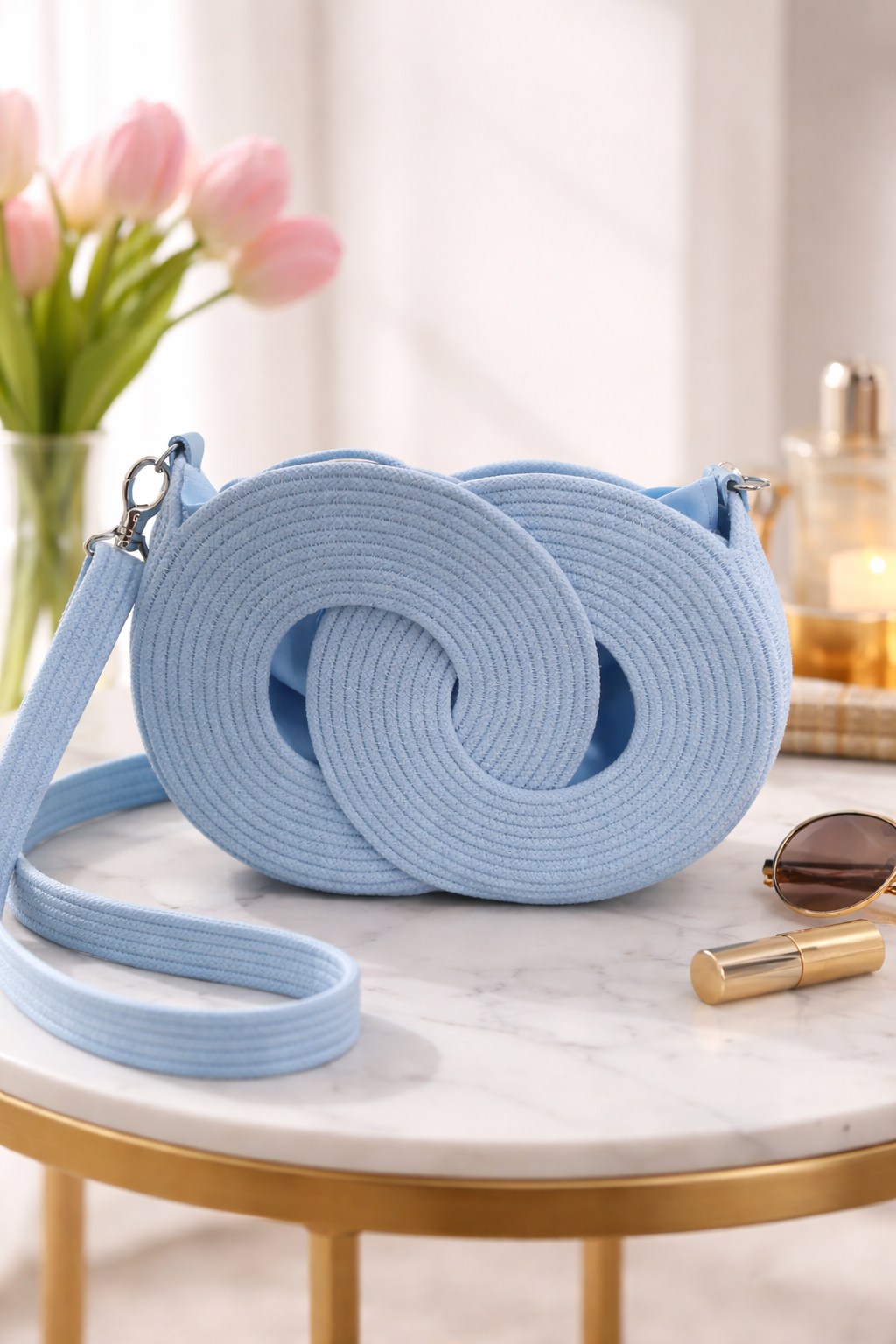 Sky blue infinity crossbody bag on marble table, handwoven cotton cord mini handbag with adjustable strap