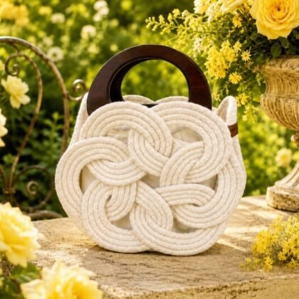 Infinity Collection ecru woven handbag with double wood handles Sculptural ecru macramé-style handbag with wooden handles Neutral woven handheld handbag with structured silhouette Infinity Collection ecru statement handbag close-up detail