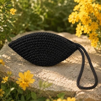 Black Macramé Wristlet from the Infinity Collection styled on model Woven black wristlet with braided loop detail Compact black macramé wristlet with zip closure Infinity Collection black woven wristlet with textured finish