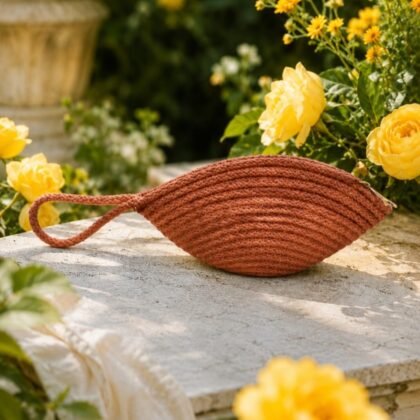 Infinity Collection sienna macramé wristlet styled on a model Woven sienna wristlet with braided wrist loop Compact sienna macramé wristlet with textured design Infinity Collection woven wristlet in warm terracotta tones