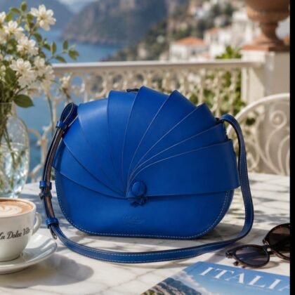 Cobalt blue Boldrini Selleria Dafne Italian leather handbag featuring a sculptural fan-inspired flap and adjustable crossbody shoulder strap.