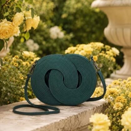 Emerald green Infinity woven handbag with double leather shoulder straps in garden setting