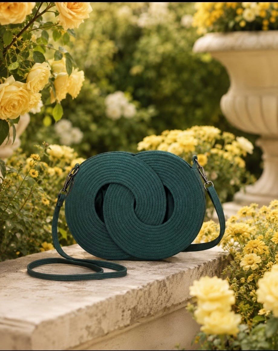 Emerald green Infinity woven handbag with double leather shoulder straps in garden setting