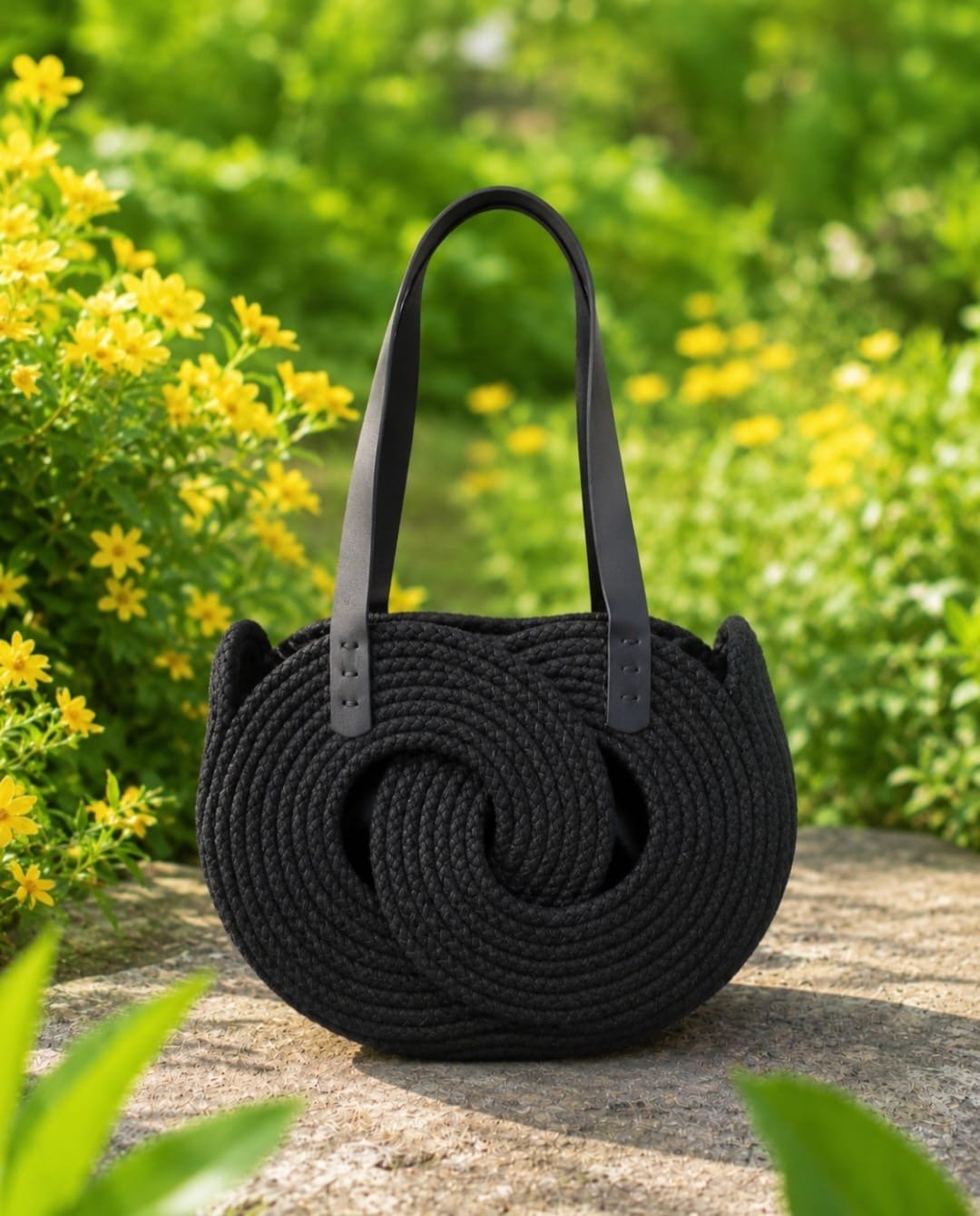 Black Infinity woven handbag with double leather shoulder straps and sculptural circular design