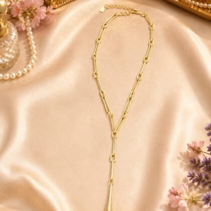 ALM SOHO gold-tone Y necklace with dark gray marbled teardrop pendant styled on neutral background