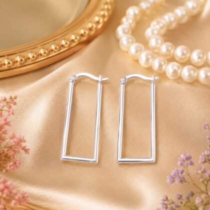 B.A. Ballou sterling silver geometric rectangle hoop earrings styled on model in soft lighting