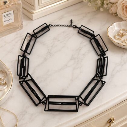Architectural black statement necklace with open rectangular geometric links in modern sculptural design.