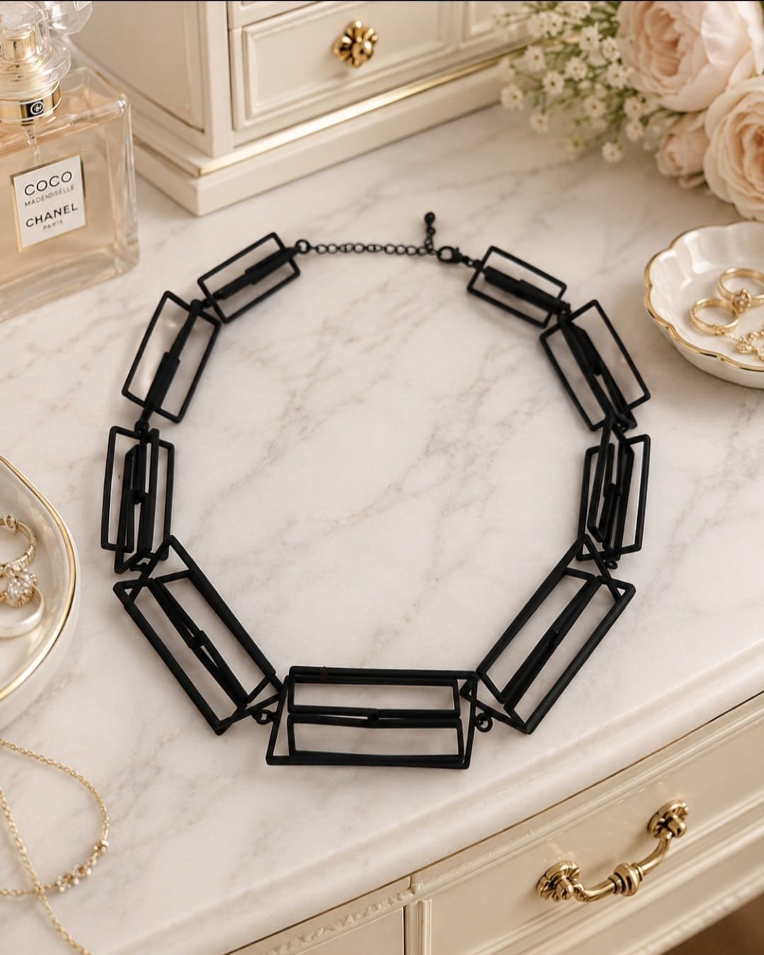 Architectural black statement necklace with open rectangular geometric links in modern sculptural design.