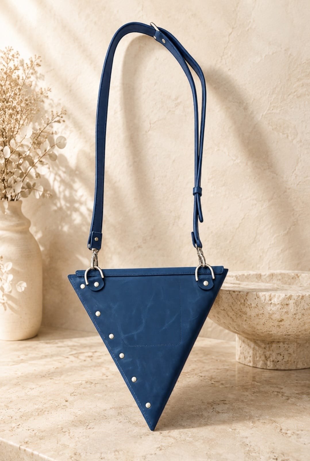 Blue Infinity genuine leather triangle crossbody bag with adjustable removable strap and geometric architectural design.