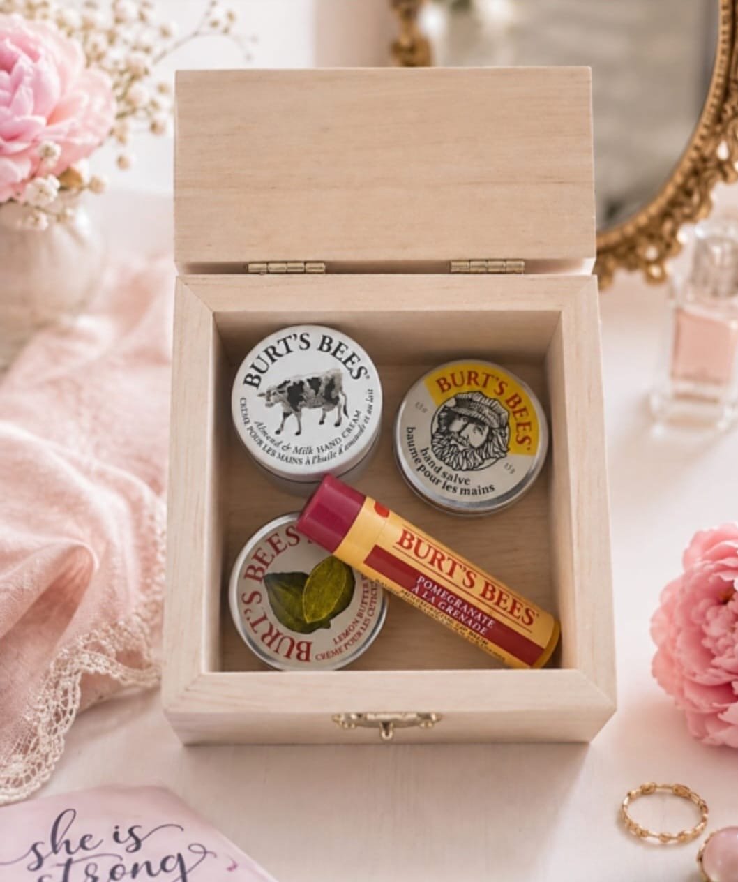 She Is Strong Proverbs 31:25 wooden keepsake gift box with pink floral and butterfly decorations and self-care products.