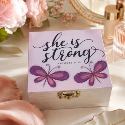 She Is Strong Proverbs 31:25 wooden keepsake gift box with pink floral and butterfly decorations and self-care products.