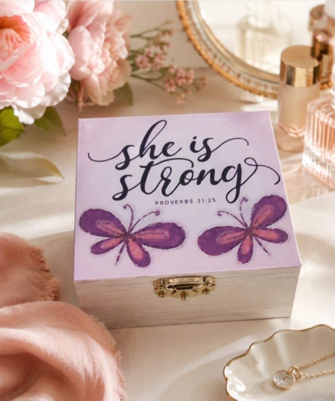 She Is Strong Proverbs 31:25 wooden keepsake gift box with pink floral and butterfly decorations and self-care products.